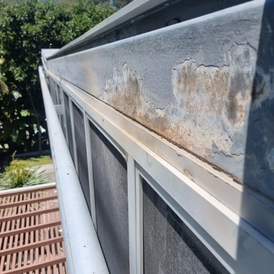 Elevated facade at Avoca Drive with areas of exposed and deteriorated coating